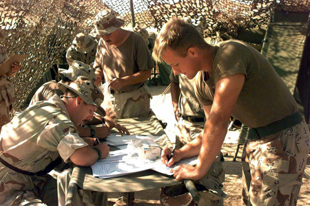 Members of the U.S. military are shown in the field filling out questionnaires.