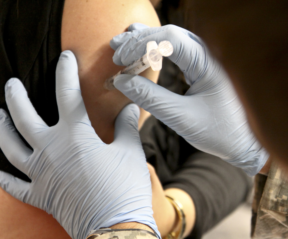 A woman getting a shot in her arm is shown here.