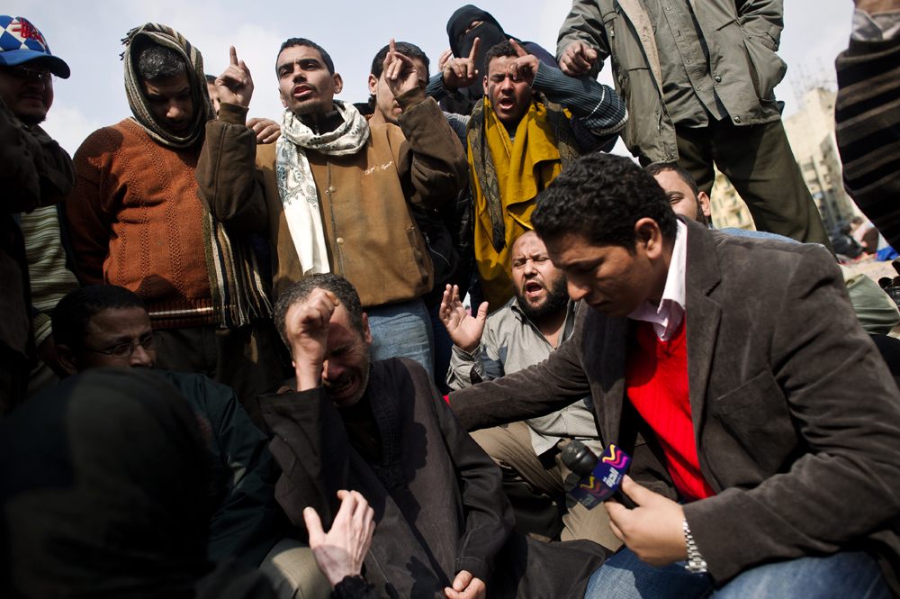 A reporter interviewing a group of protesters is shown here.