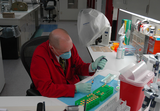 Photo depicts a scientist working in a lab.