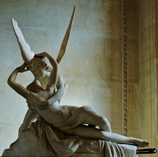 A photograph shows a sculpture of a winged man embracing a woman from behind.