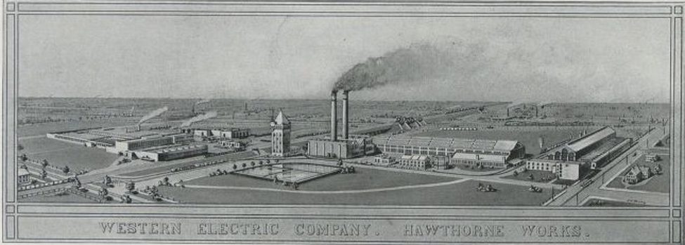 An image of a factory complex with two functioning smokestacks and a number of buildings is shown.