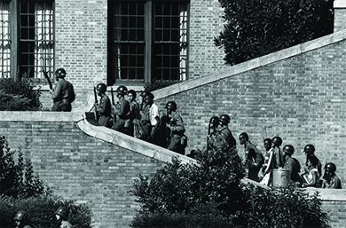 A photograph shows uniformed soldiers holding rifles as they escort the Little Rock Nine up the steps of Central High School.