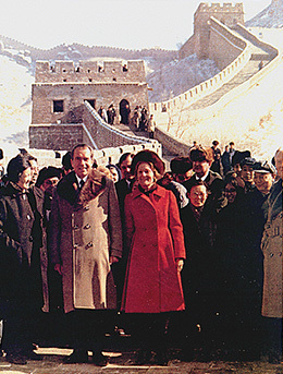 A photograph shows Richard Nixon, Patricia Nixon, and a host of officials standing in front of the Great Wall of China.