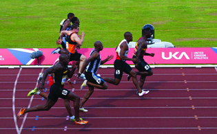 A photograph of 8 male runners in a track race.
