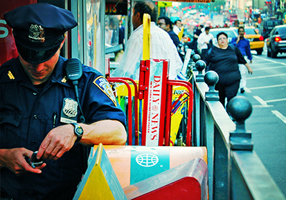 This photo is a police officer looking down at his phone and texting while on duty