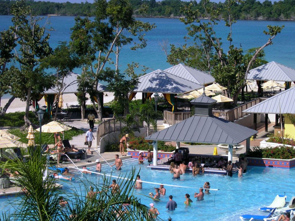 A swimming pool full of people at a resort.