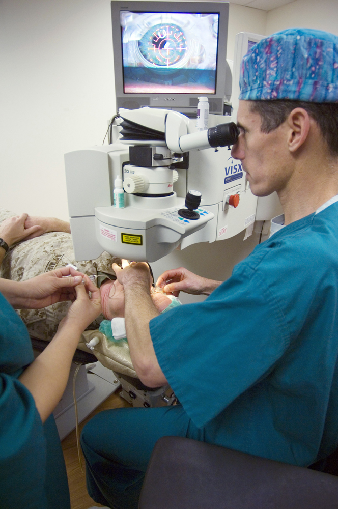 The image depicts a surgeon using state-of-the-art equipment for LASIK surgery on a patient who is lying down.