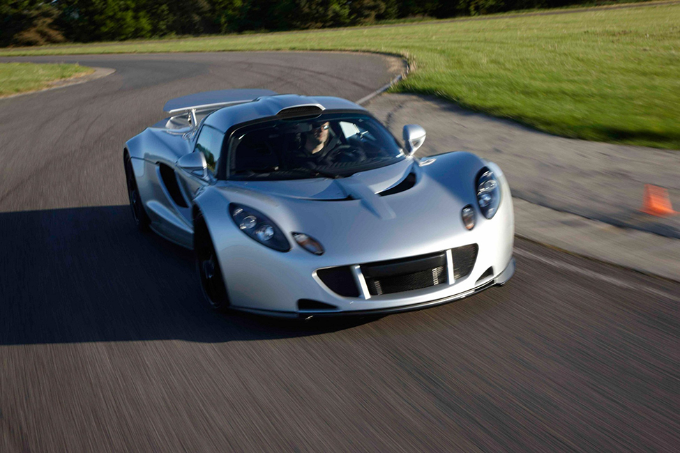 A photo of a Hennessey Venom GT sports car speeding along a winding road.