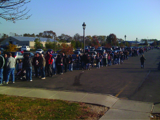 An image of a large group of people lined up along a sidewalk.