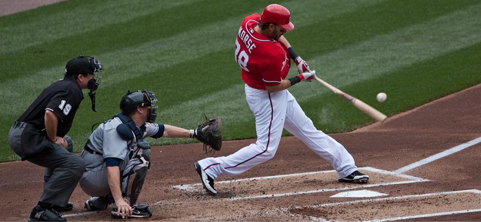 Baseball batter hitting a ball. There is also a catcher and an umpire shown.